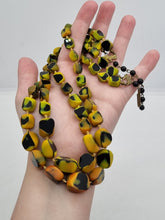 Load image into Gallery viewer, 1950s Black, Yellow and Orange Marbled Knotted Glass Necklace

